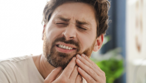 persona notando dolor al morder un alimento blando